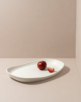 Mini stoneware serving platter with a selection of pastries and blackberries on a kitchen countertop.